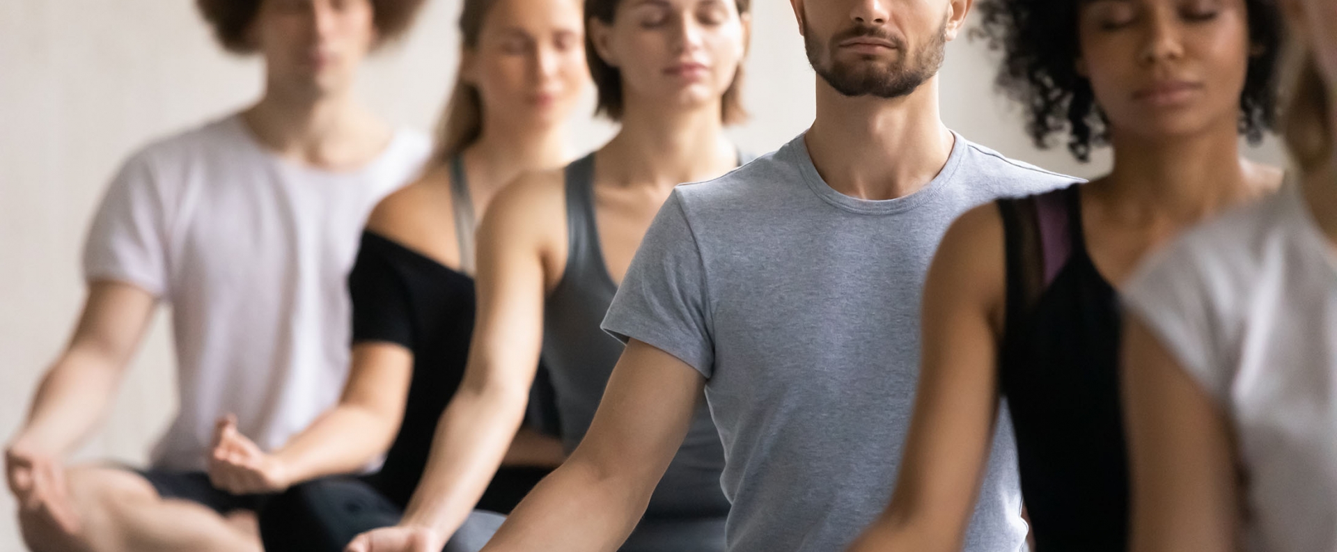 Group of diverse people meditating together visualizing during yoga morning session