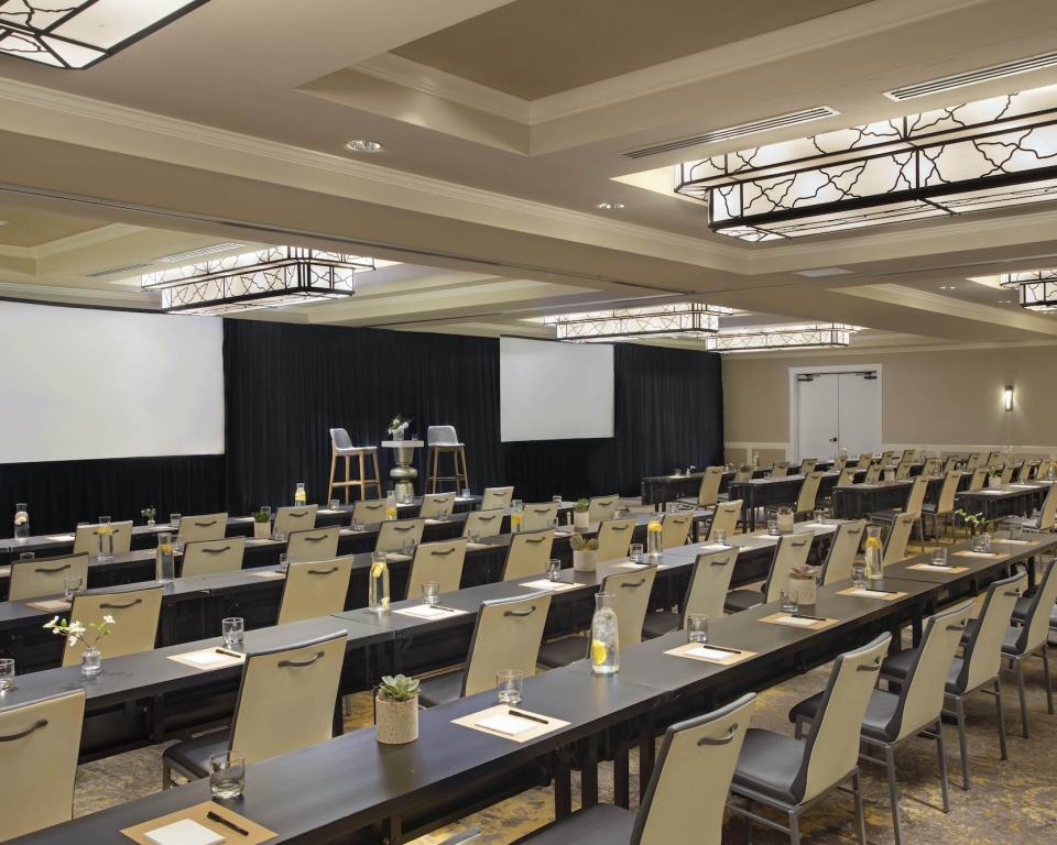 Ballroom set schoolroom style with stage and screens