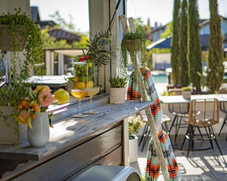 Two colorful mixed drinks sit on the High Horse outdoor bar top.