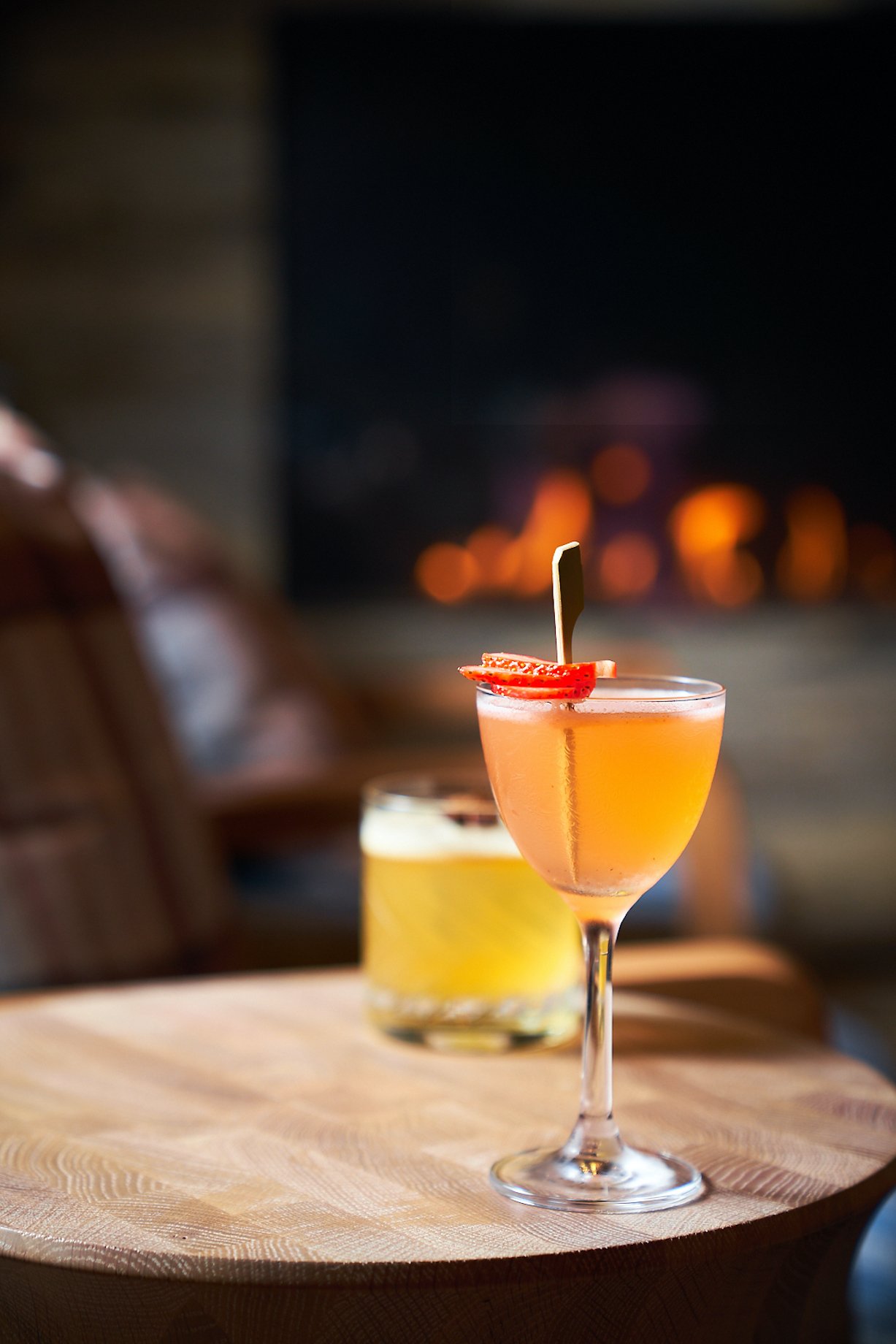 Two colorful cocktails served on a wooden tabletop.