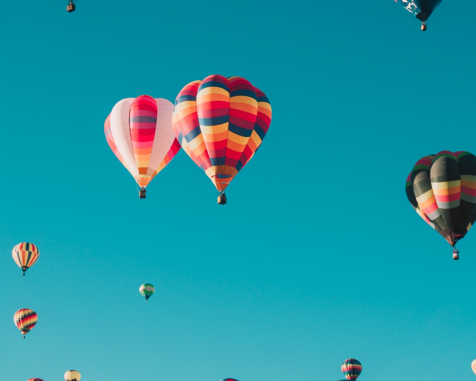 Dozens of hot air balloons in the sky