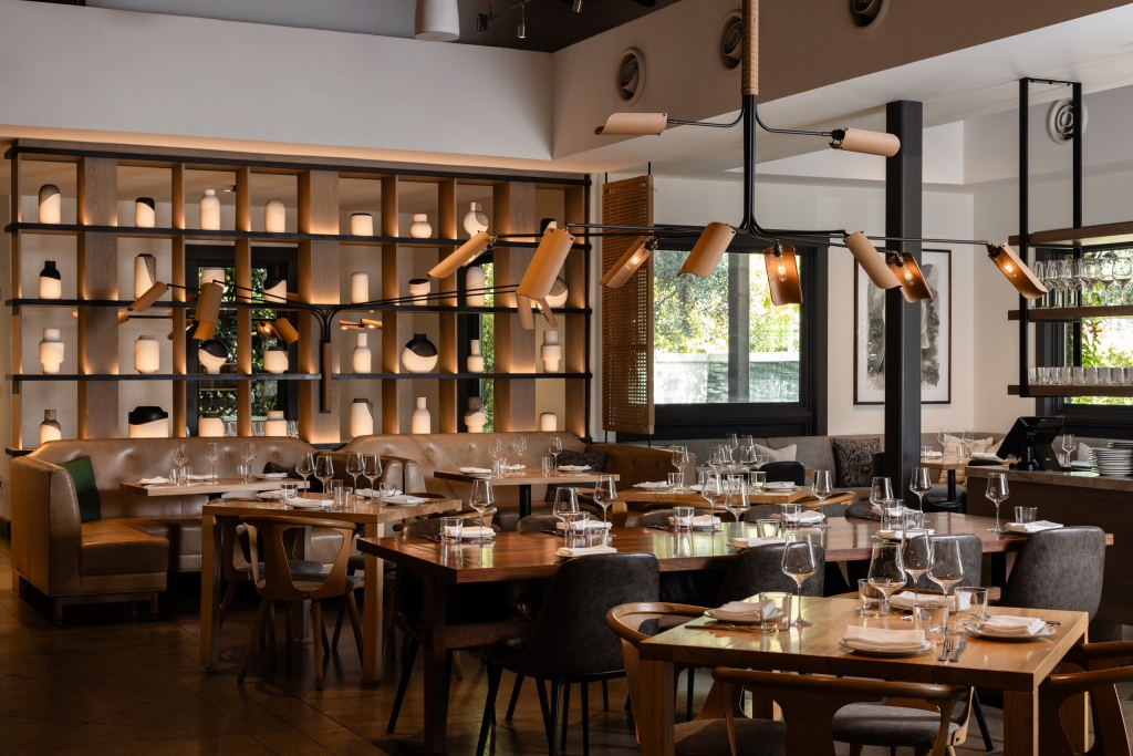Elegant Sonoma restaurant with leather banquettes, ceramic vase wall display, custom pendant lights, and wood dining tables set with stemware.